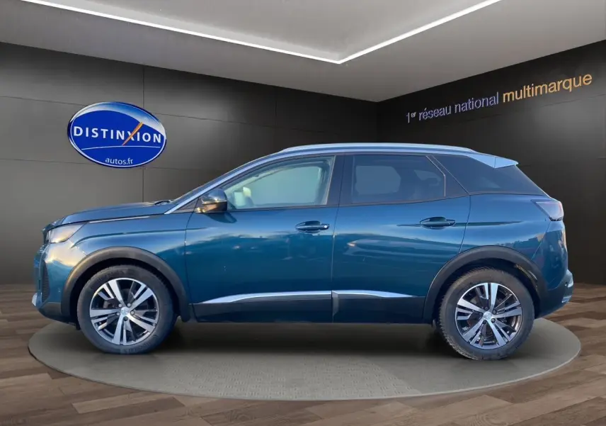 Vue de profil côté gauche d’un Peugeot 3008 Bleu Célèbes 2021 en showroom avec jantes alliage et toit noir.
