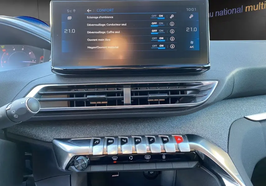 Vue rapprochée de la console centrale du Peugeot 3008 Bleu Célèbes 2021, écran tactile et commandes chromées visibles.
