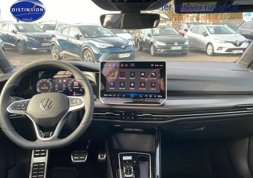 Vue intérieure avant de la Volkswagen Golf gris 2026, volant multifonction et écran tactile central lumineux.