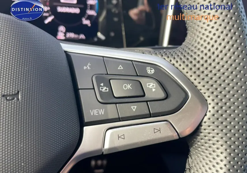 Gros plan sur les commandes multifonctions du volant cuir perforé de la Volkswagen Golf gris 2026.