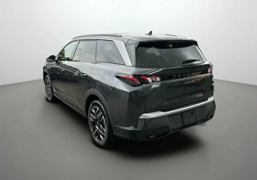 Peugeot 5008 Hybrid gris titane avec toit noir, vue 3/4 arrière droit, jantes alu 19 pouces et feux LED distinctifs.