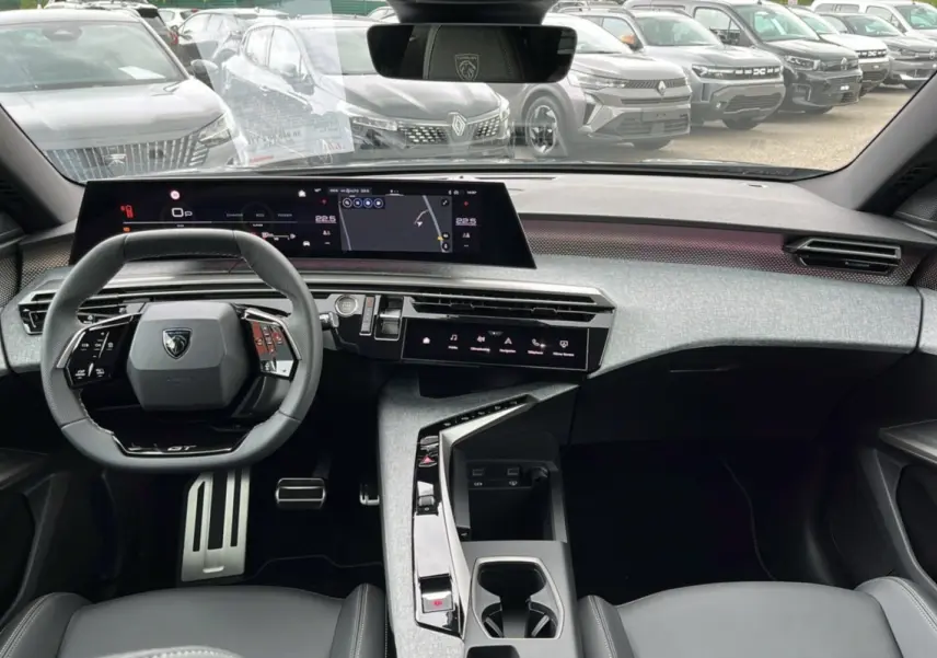 Vue intérieure frontale du Peugeot 5008 Hybrid 145 GT 2025, tableau de bord moderne avec écran large et volant cuir multifonctions.