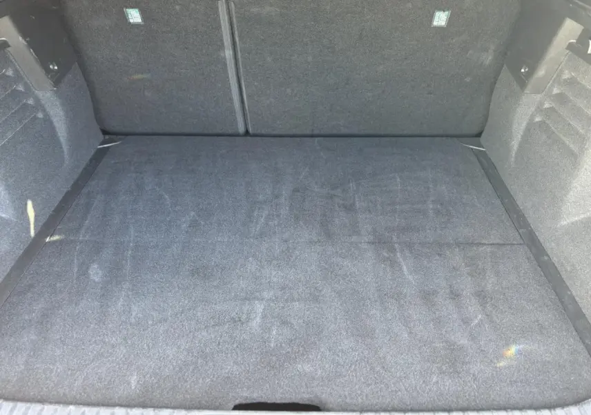 Vue plongeante sur le coffre spacieux et propre du Renault SYMBIOZ gris Cassiopée, sans chargement visible.