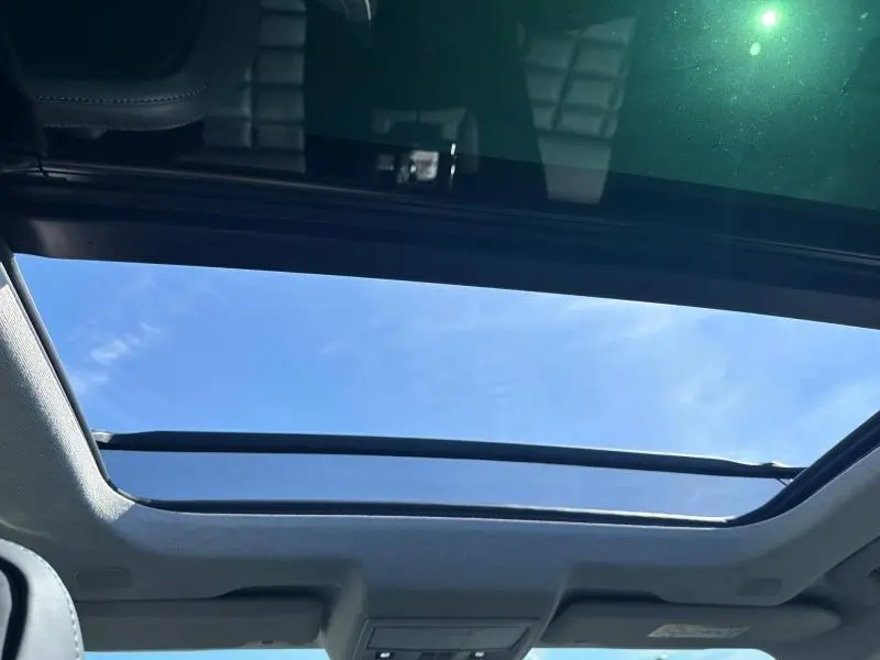 Toit ouvrant panoramique ouvert sur ciel bleu dans un Citroën C5 Aircross Gris Platinium 2026.