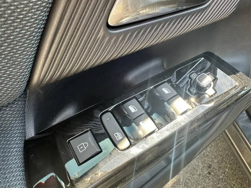 Gros plan sur les commandes de lève-vitres et rétroviseurs côté conducteur du Citroën C5 Aircross gris Platinium.