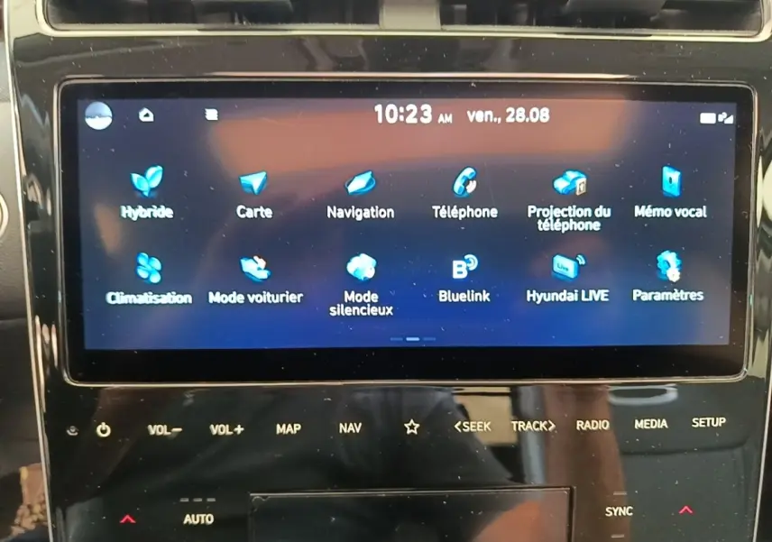 Écran tactile central du Hyundai Tucson blanc 2022 affichant le menu principal des fonctions connectées.