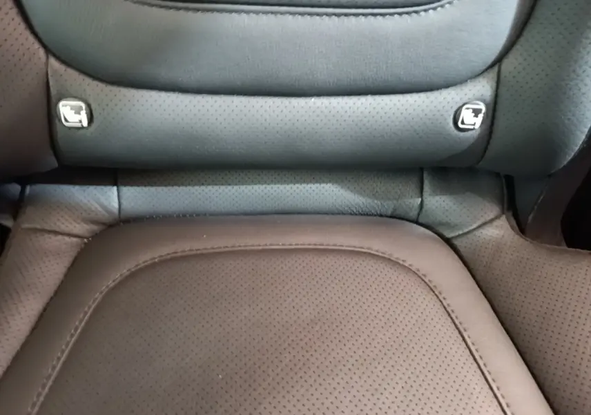 Gros plan sur l’assise en cuir noir perforé d’un siège arrière du Hyundai Tucson 1.6 Hybrid 230 Executive.