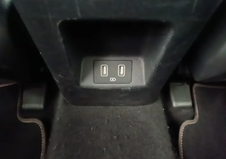 Prise USB double pour recharge située à l'arrière de la console centrale dans l'habitacle noir du Hyundai Tucson blanc.