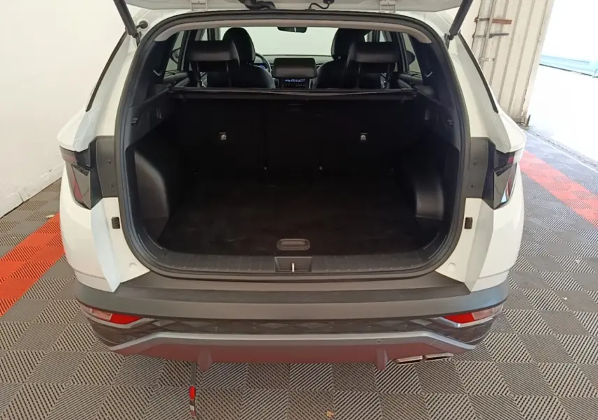 Vue arrière du Hyundai Tucson blanc 2022 avec coffre ouvert et intérieur noir visible.