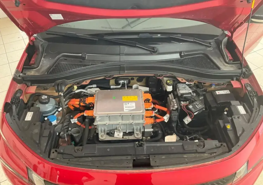 Vue plongeante sur le moteur électrique et câblage orange du Citroën C3 ë-113 Berline Max rouge métal 2025 avec capot ouvert.
