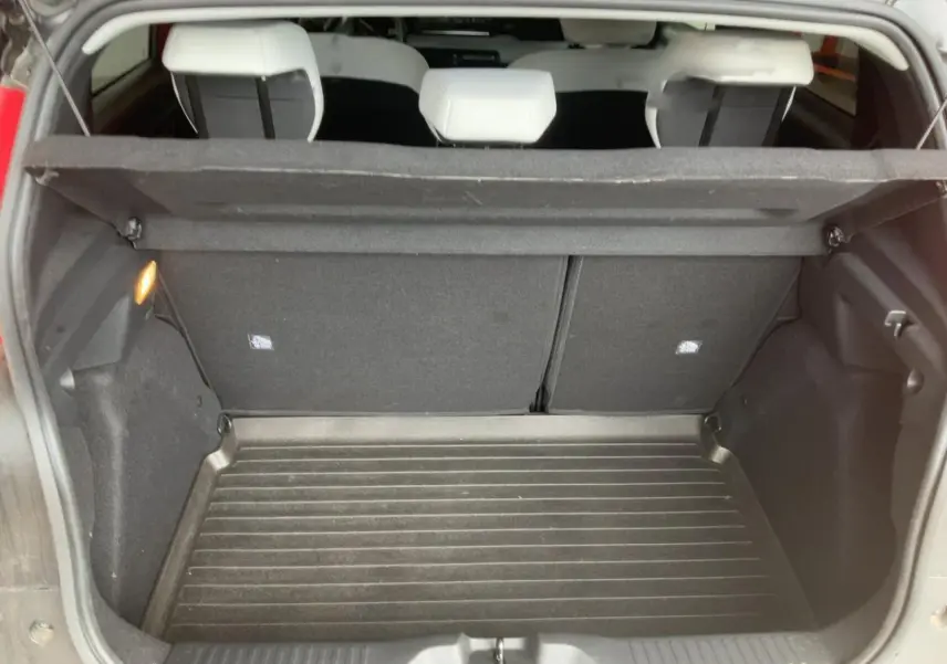 Coffre ouvert vu de l'arrière d'une Citroën C3 ë-113 Berline Max 2025 rouge métal foncé, intérieur noir.