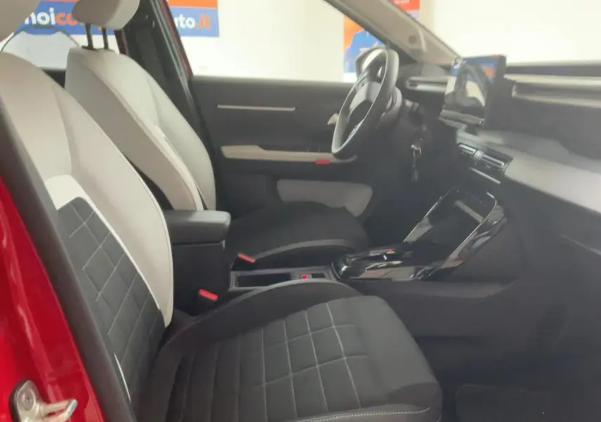 Intérieur côté gauche de la Citroën C3 ë-113 Berline Max 2025, sièges bicolores noirs et blancs, tableau de bord moderne.