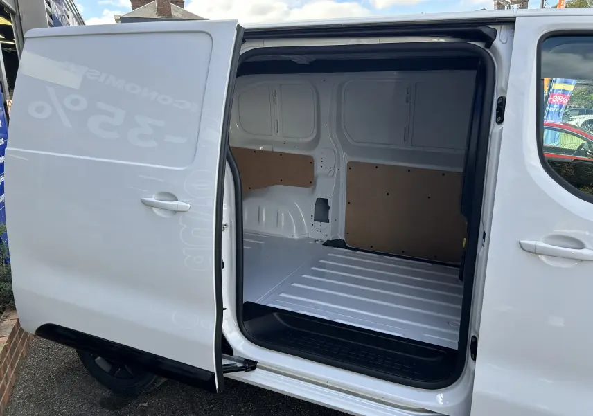 Vue latérale droite d’un Citroën Jumpy blanc 2025 avec porte coulissante ouverte montrant l’espace de chargement vide.