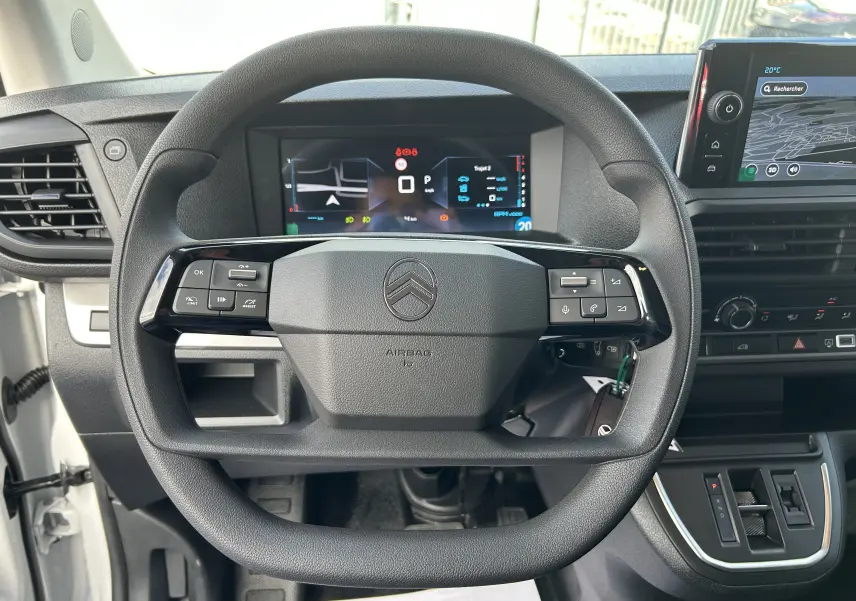 Vue intérieure centrée sur le volant noir du Citroën Jumpy 2025 avec tableau de bord numérique et écran tactile.