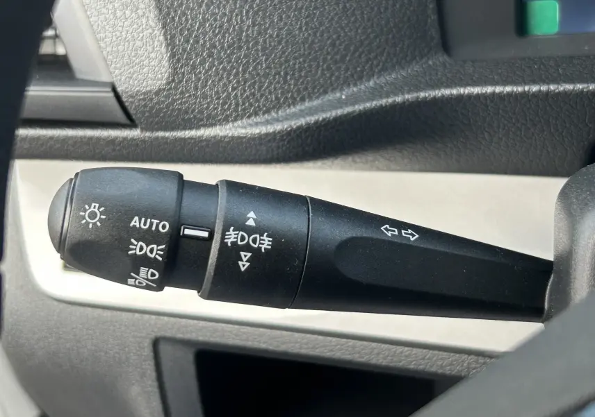 Gros plan sur la manette de clignotants et commandes d’éclairage du tableau de bord du Citroën Jumpy blanc.