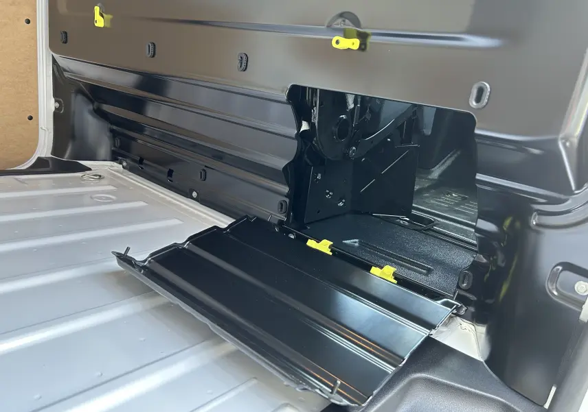 Détail intérieur du plancher et cloison de chargement noir ouvert du fourgon blanc Citroën Jumpy 2025, vue rapprochée côté gauche.