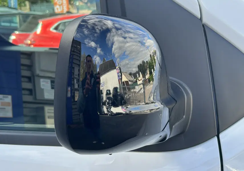 Rétroviseur droit noir brillant du Citroën Jumpy blanc, vue rapprochée sur la porte avant côté droit.
