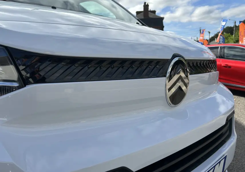 Gros plan sur la calandre avant blanche du Citroën Jumpy 2025 avec logo chromé et détails noirs brillants.