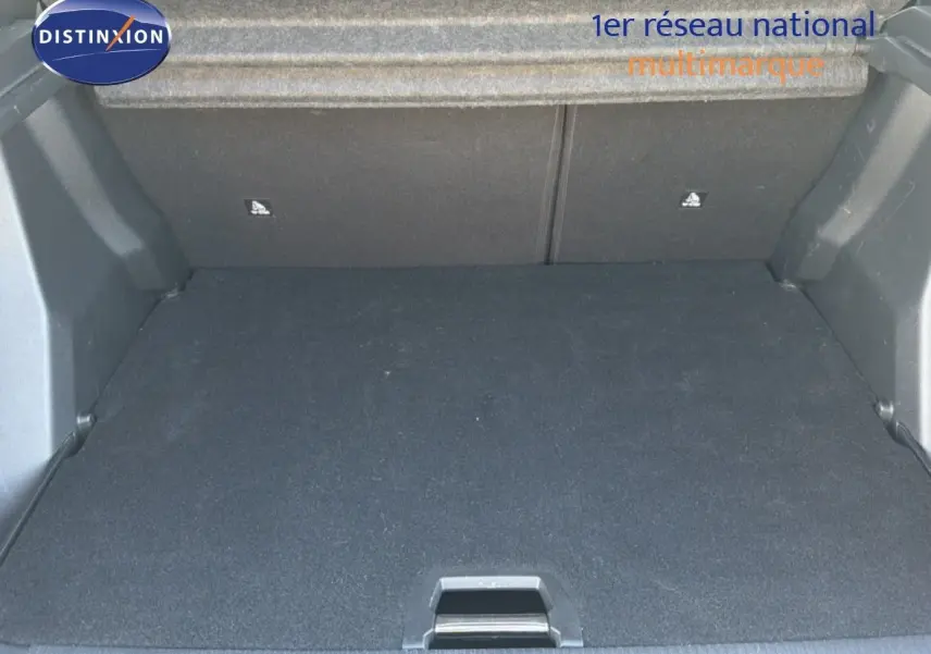 Coffre ouvert de la Peugeot 2008 gris platinium, vue intérieure montrant l'espace de chargement vide et le revêtement noir.