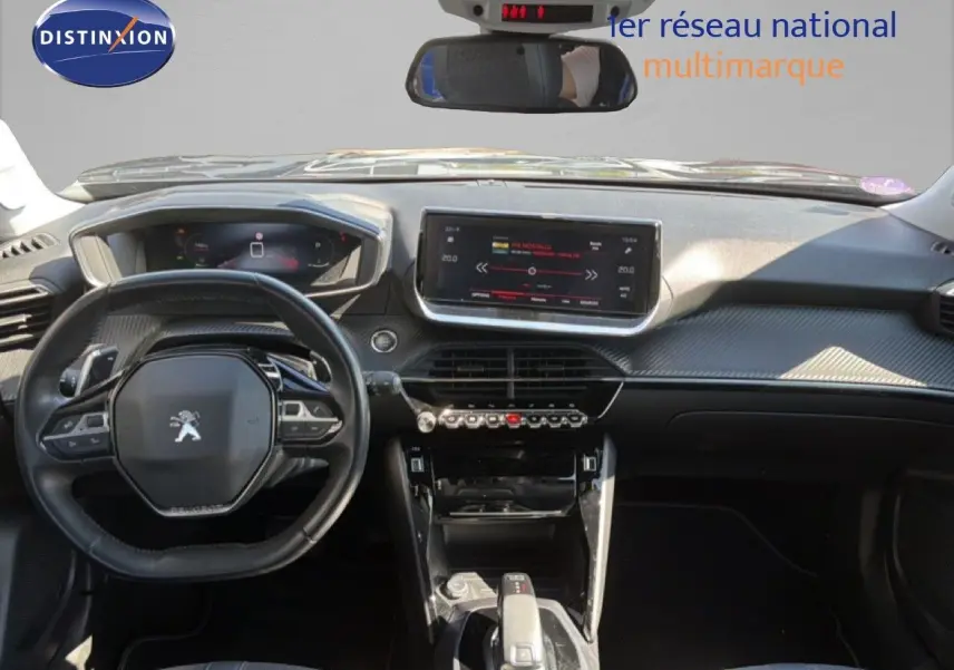Vue intérieure avant du tableau de bord et volant noir de la Peugeot 2008 gris platinium avec écran tactile central et commandes modernes.