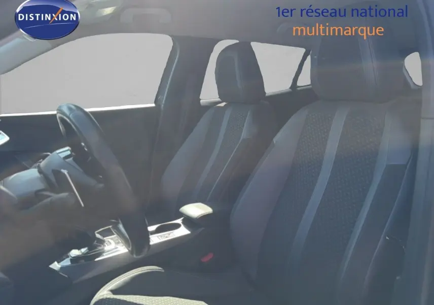 Vue intérieure côté conducteur du Peugeot 2008 gris platinium, mettant en valeur les sièges en tissu et cuir noir.