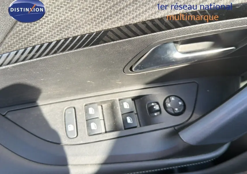 Gros plan sur la commande des vitres et rétroviseurs côté conducteur d'une Peugeot 2008 gris platinium.