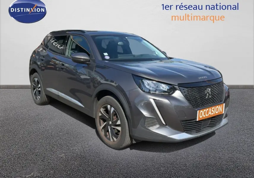 Peugeot 2008 gris platinium en 3/4 avant droit, avec calandre noire et jantes bi-ton visibles.