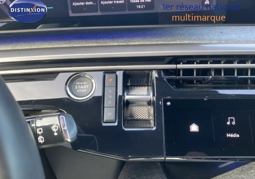 Détail du tableau de bord noir brillant du Peugeot 5008 Hybrid avec bouton start/stop et commandes de boîte automatique.