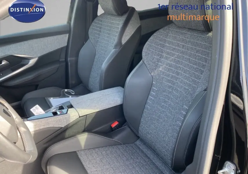 Vue intérieure côté conducteur du Peugeot 5008 Hybrid 2025, sièges tissu gris et cuir noir, porte ouverte sur carrosserie noire.