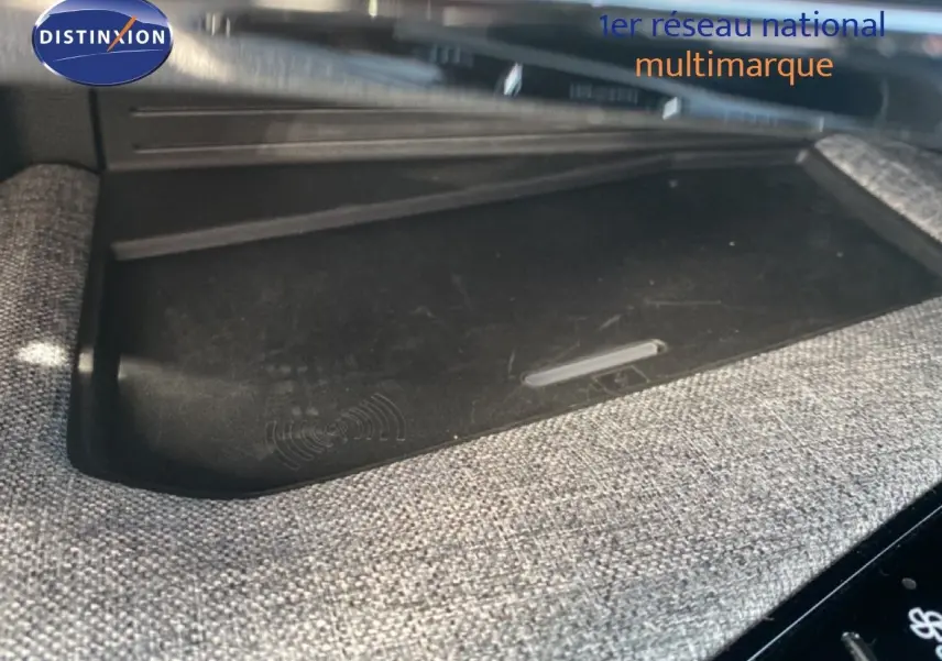 Détail intérieur montrant le chargeur sans fil intégré dans la console centrale du Peugeot 5008 Hybrid 2025 noir Perla Nera.