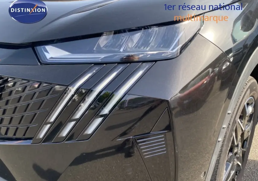 Gros plan sur l'avant droit noir Perla Nera du Peugeot 5008 Hybrid 2025, mettant en valeur le phare et la calandre distinctive.