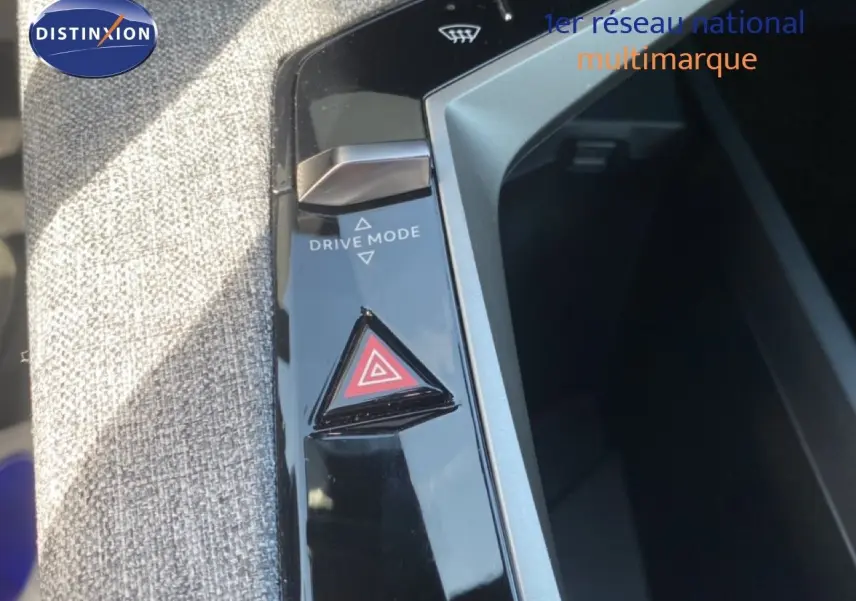 Gros plan sur la console centrale du Peugeot 5008 noir, montrant le bouton triangle de warning et la commande Drive Mode.