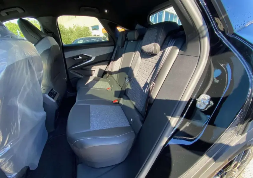 Vue intérieure côté droit des sièges arrière du Peugeot 3008 noir 2025, avec sellerie mixte tissu et cuir.