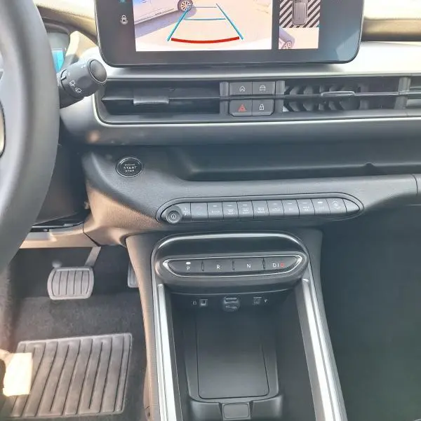 Vue intérieure du tableau de bord du Jeep Avenger électrique blanc, avec écran tactile affichant la caméra de recul.