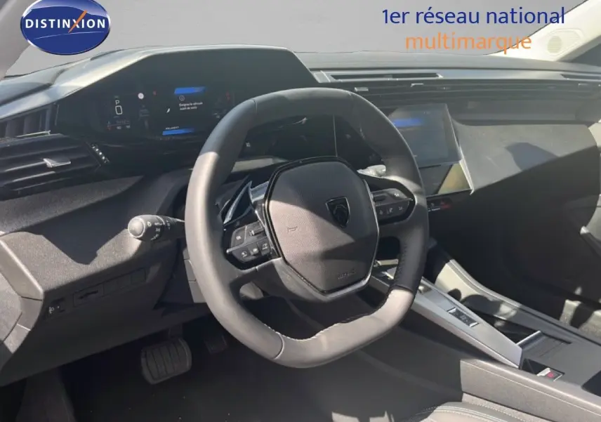 Vue intérieure du poste de conduite de la Peugeot 308 Hybrid 145ch Allure 2025, volant cuir noir et tableau de bord digital.