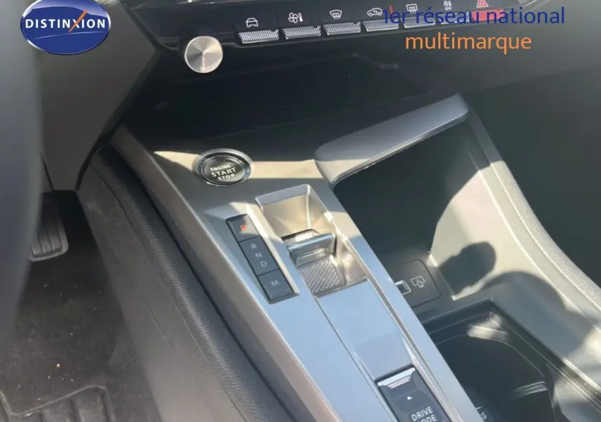 Gros plan sur la console centrale grise avec bouton start/stop et levier de boîte automatique dans une Peugeot 308 noir métal 2025.