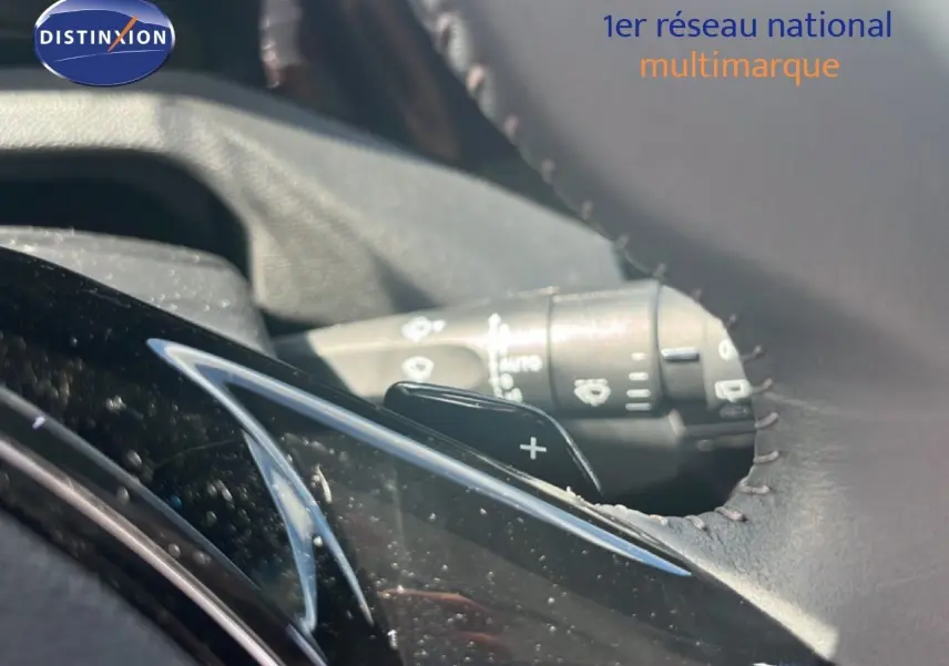 Gros plan sur la palette de changement de vitesse côté droit du volant en cuir noir d’une Peugeot 308 Hybrid 2025 noir métal.