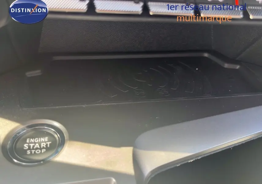 Gros plan sur le bouton start/stop et la zone de recharge sans fil dans l'habitacle d'une Peugeot 308 noir métal.