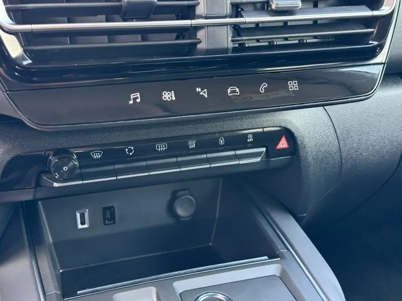 Vue rapprochée de la console centrale noire du Citroën C5 Aircross 2025 avec commandes tactiles et prises USB visibles.