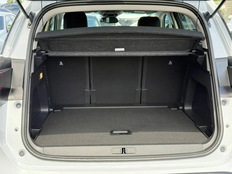 Coffre ouvert vu de l'arrière du Citroën C5 Aircross blanc Okénite, montrant un espace de chargement spacieux et propre.