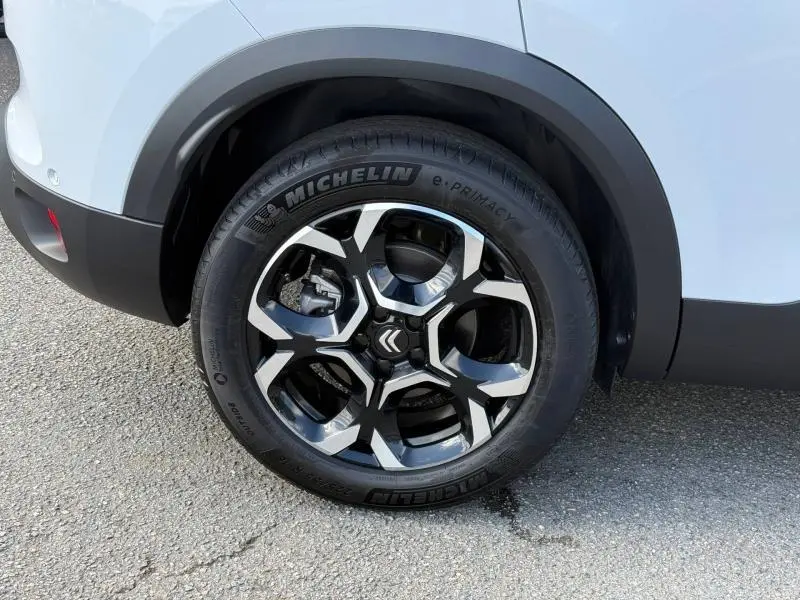 Gros plan sur la roue avant droite du Citroën C5 Aircross blanc Okénite avec jante alliage noire et argentée.