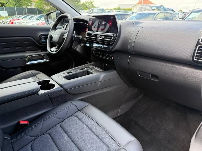 Vue intérieure côté passager du Citroën C5 Aircross hybride 2025, tableau de bord moderne avec écran tactile central.