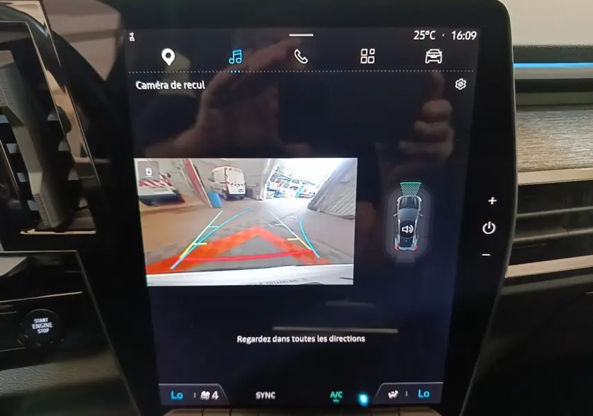 Écran tactile central du Renault Austral blanc montrant la caméra de recul et l’aide au stationnement en intérieur.