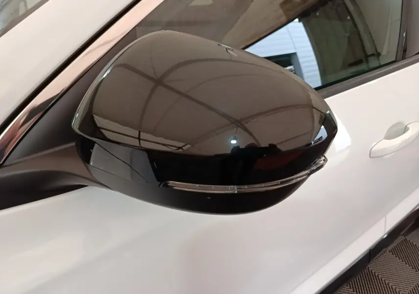 Rétroviseur droit noir brillant du Renault Austral blanc, vue rapprochée sur la portière côté droit.