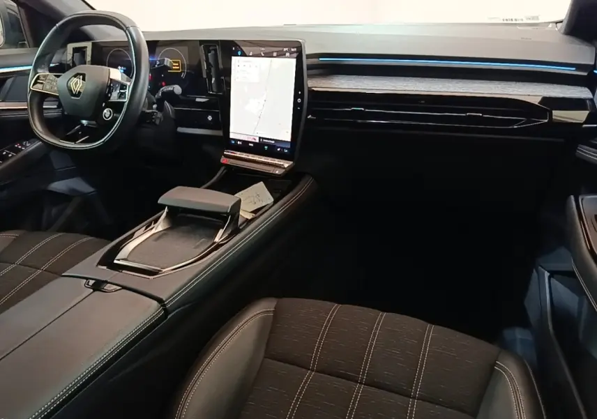 Intérieur noir du Renault Austral 2023 vu côté passager, avec grand écran tactile central affichant la navigation.