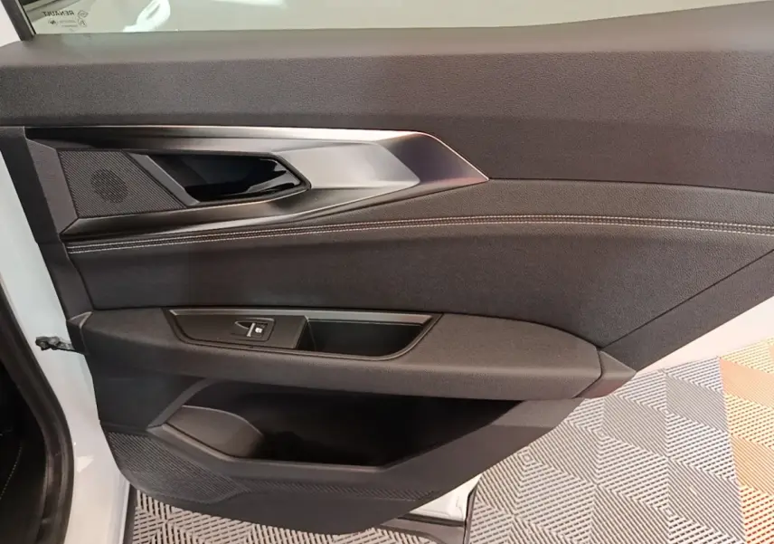 Vue rapprochée de la porte avant gauche noire du Renault Austral blanc, avec poignée et commandes de fenêtre intégrées.