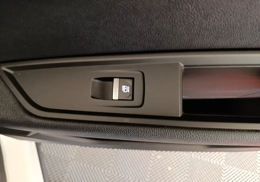 Gros plan sur le bouton de commande de lève-vitre électrique côté porte avant d’un Renault Austral blanc.
