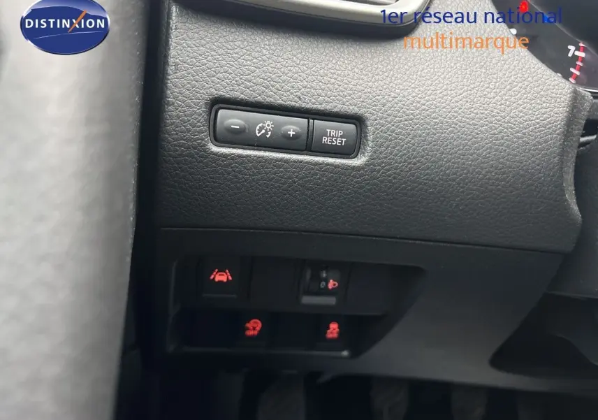 Gros plan sur les commandes de réglage du tableau de bord et des aides à la conduite du Nissan Qashqai blanc Glacier.