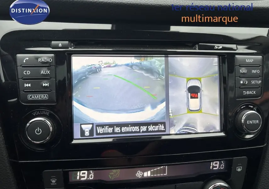 Écran central du Nissan Qashqai blanc montrant la caméra de recul et la vue à 360 degrés intérieure.