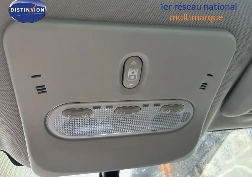 Plafonnier intérieur gris clair du Nissan Qashqai blanc glacier, vue en contre-plongée centrée sur les commandes d’éclairage.